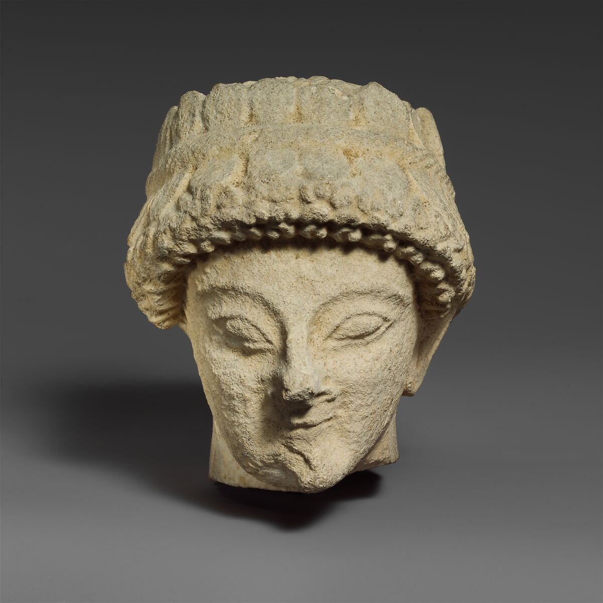 Limestone head with of a beardless male with a wreath of leaves, Limestone, Cypriot 