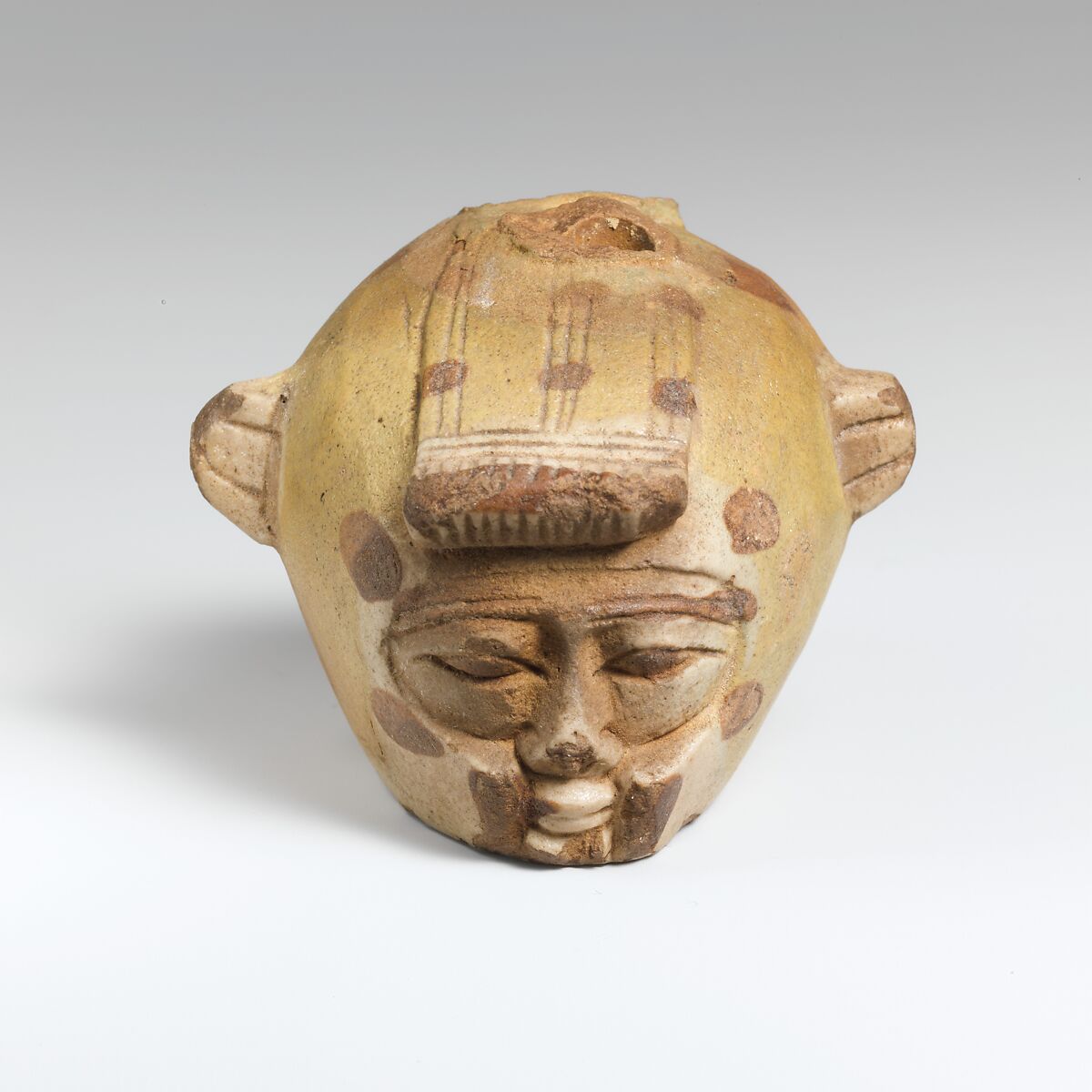 Faience aryballos (oil flask) in the form of a head wearing an animal skin, Faience, East Greek 