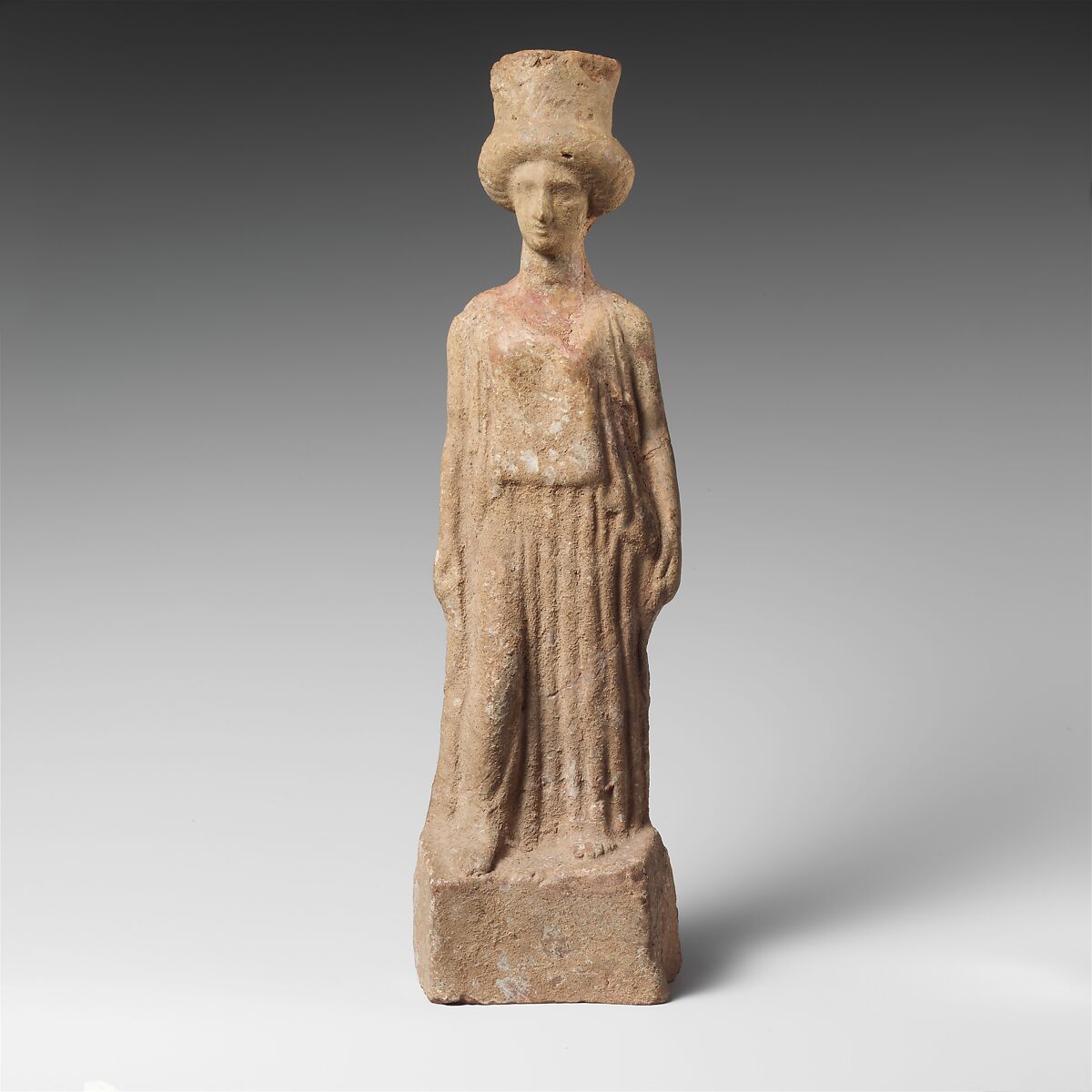 Terracotta statuette of a standing woman, Terracotta
Fabric: (figurine is too dirty to read fabric).
Slip, paint: white slip, red paint on chest.
Method of manufacture: moldmade, hollow; head also hollow, molded separately. Base in one mold with torso.
Back, venting: back handmade, flattened. Very large rectangular ("open door") vent from chest to base., Greek, Boeotian 