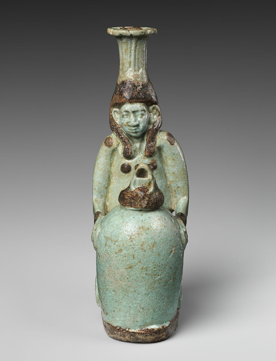 Faience double-spouted vessel in the form of a kneeling woman holding a jar, Faience, East Greek