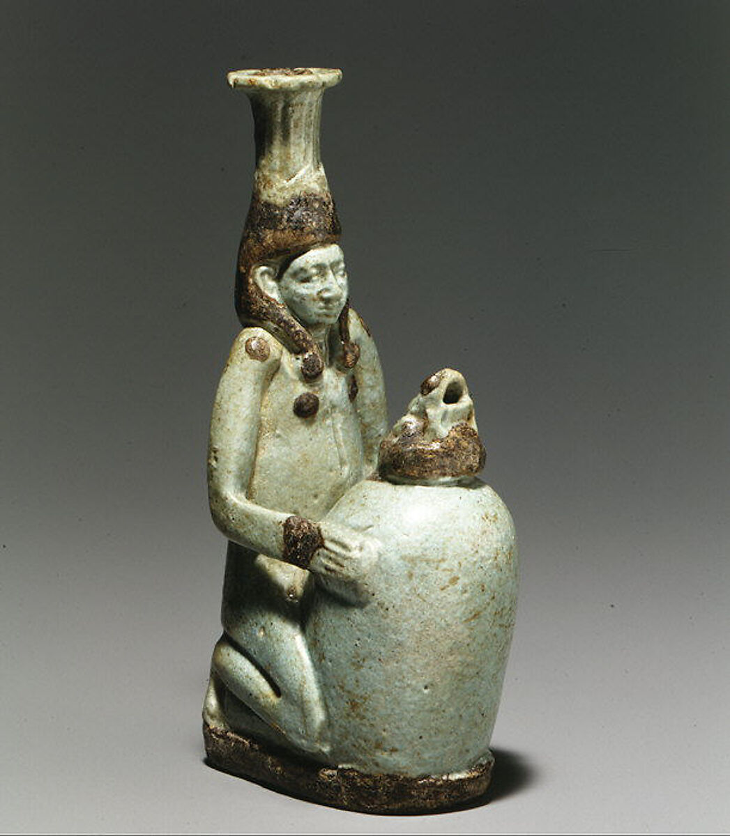 Faience double-spouted vessel in the form of a kneeling woman holding a jar, Faience, East Greek 