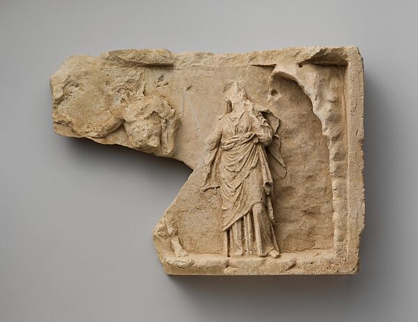 Fragment of a limestone relief with two standing figures