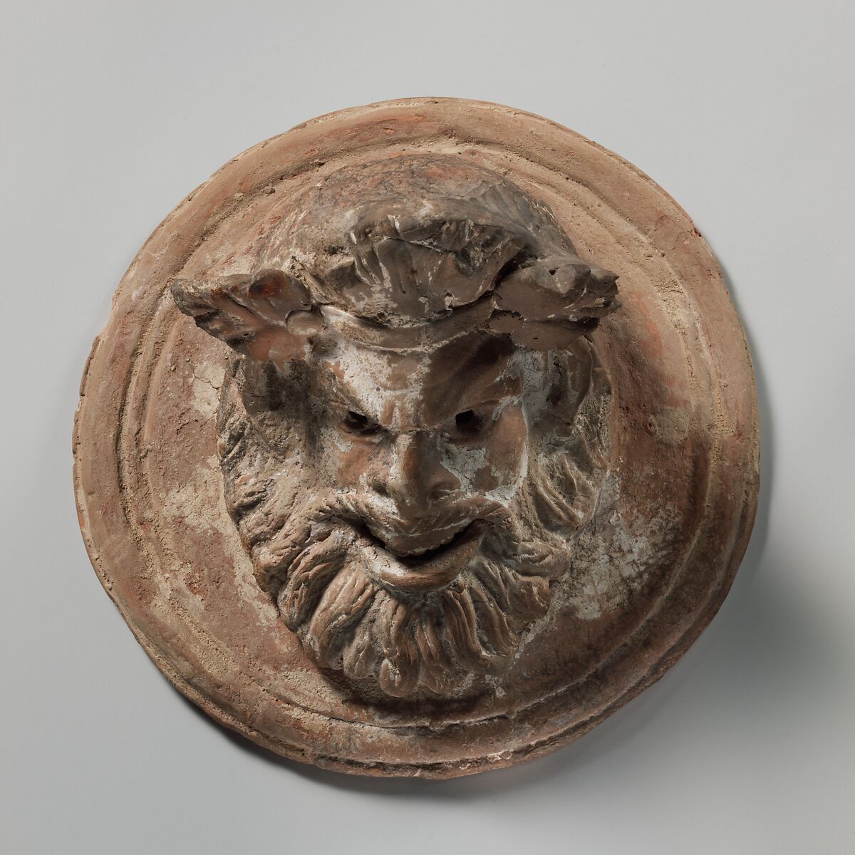 Terracotta roundel with mask of Pan, Terracotta, Greek