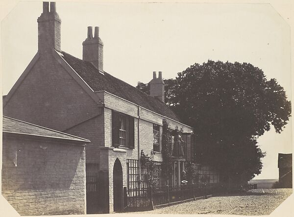 [House with Woman on Balcony, Man Standing Below]