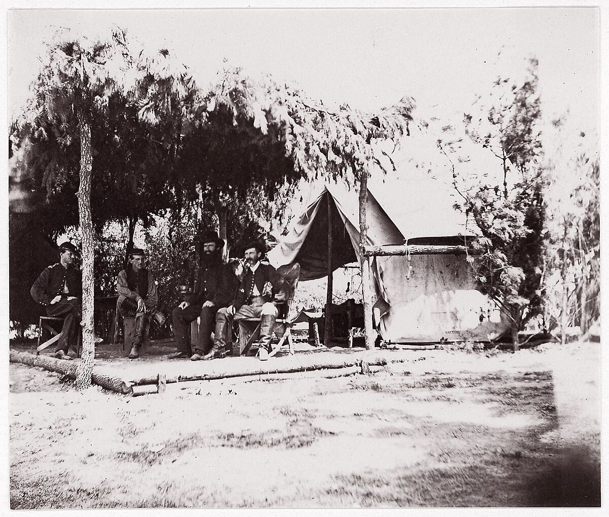 [Four men in camp under a lean-to of pine boughs], Unknown (American), Albumen silver print from glass negative 