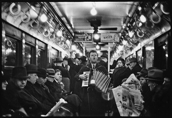 [Four 35mm Film Frames: View Down Subway Car: Accordionist Performing in Aisle, Newspaper Vendor in Aisle, New York City]