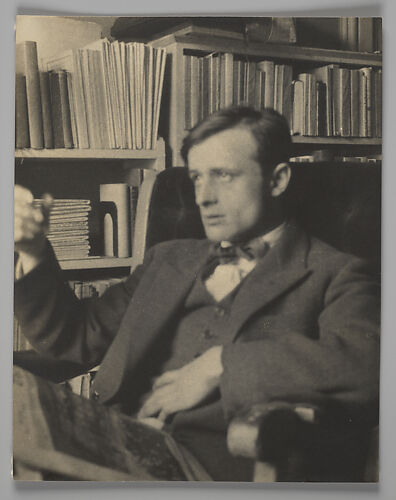 [Hanns Skolle, Seated Before Bookshelves in Apartment at 448 West 20th Street, New York City]
