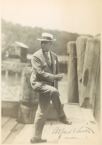 [Copy of Signed Photograph of Alfred E. Smith, Governor of New York, Standing on Dock in Suit and Hat, Holding Sandwich]