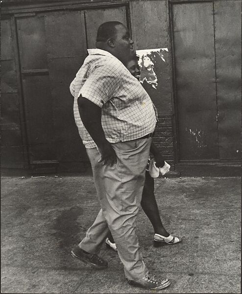 [Man Wearing Short-Sleeved Plaid Shirt and Woman in Sandals Walking on Street, New York], Leon Levinstein (American, Buckhannon, West Virginia 1910–1988 New York), Gelatin silver print 