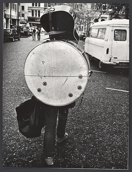 [Man From Behind Carrying Guitar and Drum Set, Great Britain], Leon Levinstein (American, Buckhannon, West Virginia 1910–1988 New York), Gelatin silver print 