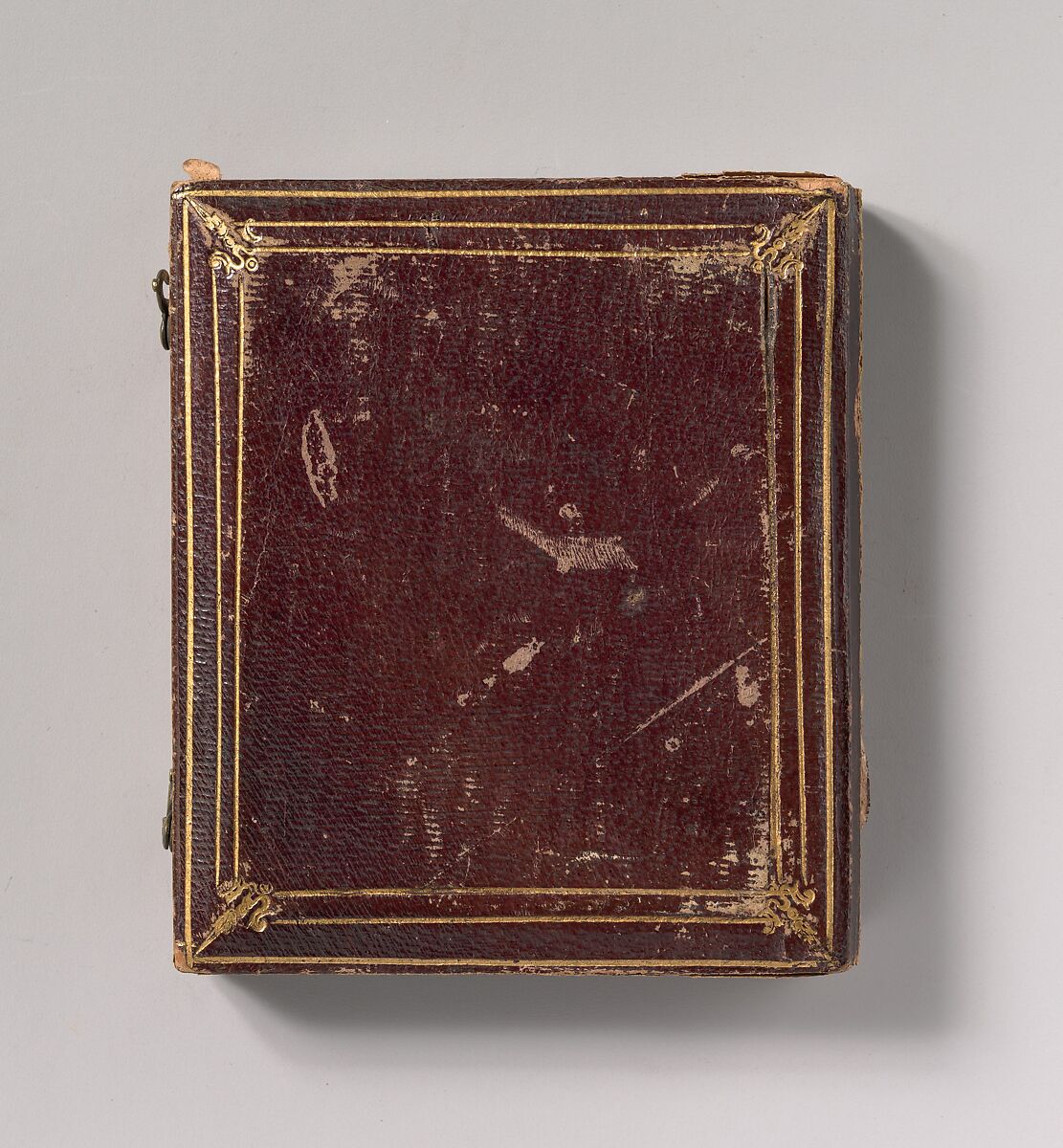 [Seated Young Man Resting Arm on Table Beside Daguerreotype Case], Unknown (American), Daguerreotype with applied color