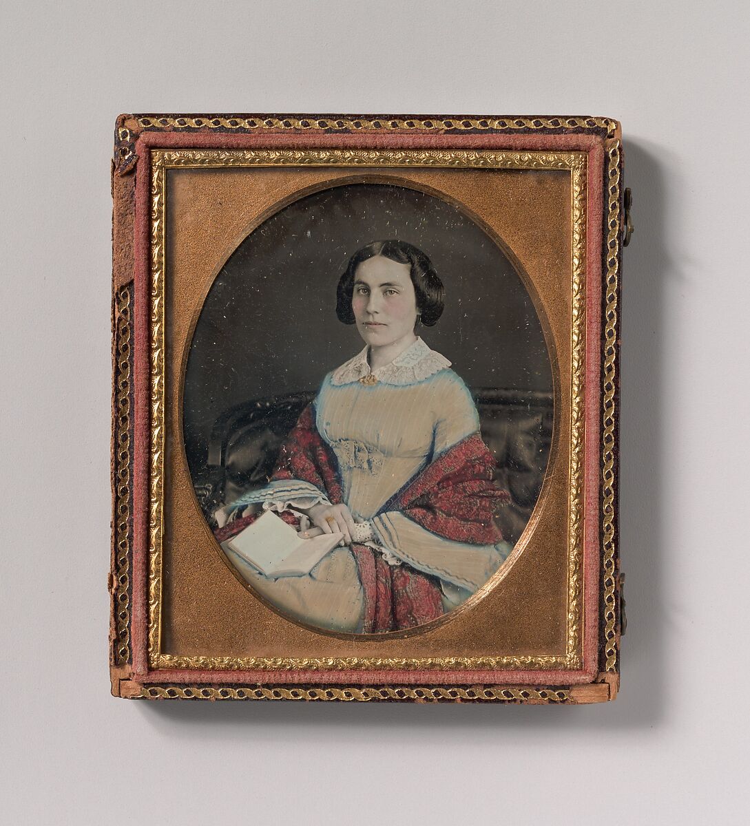 [Seated Young Woman Wearing a Shawl, Holding an Open Book in her Lap], Unknown (American), Daguerreotype with applied color 