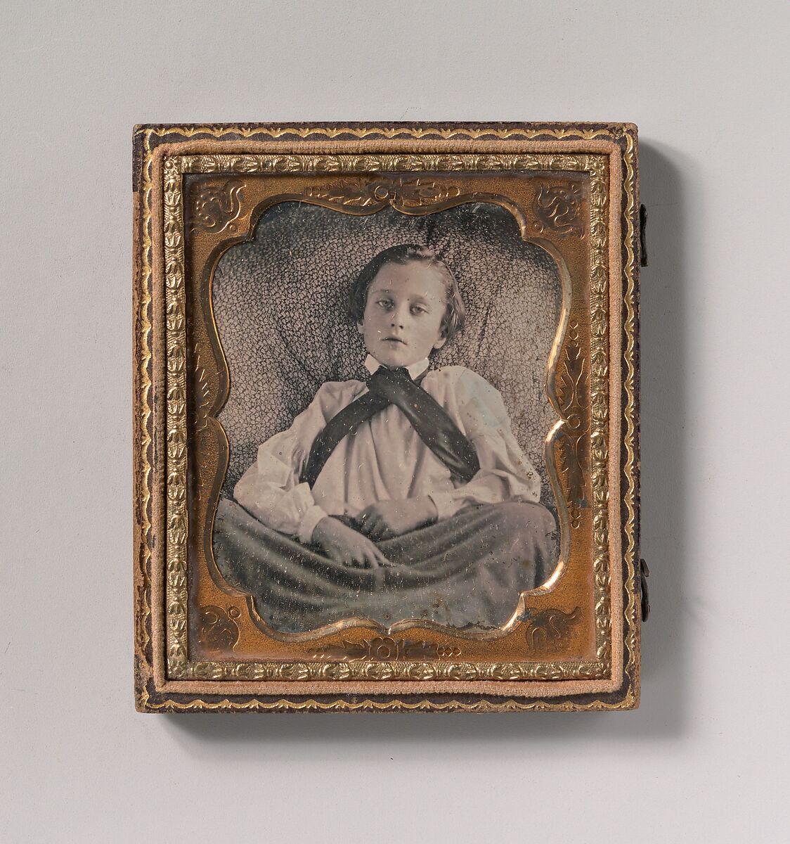 [Boy Seated Cross-legged, Partially Covered by Blanket, Leaning Against Cushion], Unknown (American), Daguerreotype 