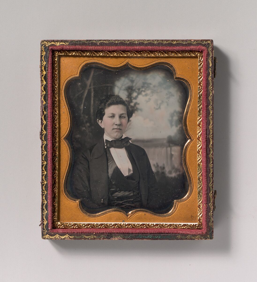 [Young Man Seated in Front of Painted Outdoor Backdrop], Unknown (American), Daguerreotype with applied color 