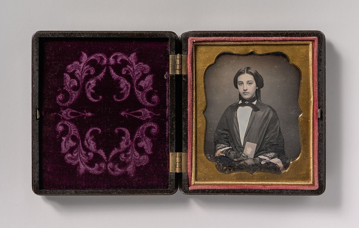 [Young Woman Wearing Lace Gloves Holding a Daguerreotype Case], Unknown (American), Daguerreotype with applied color 