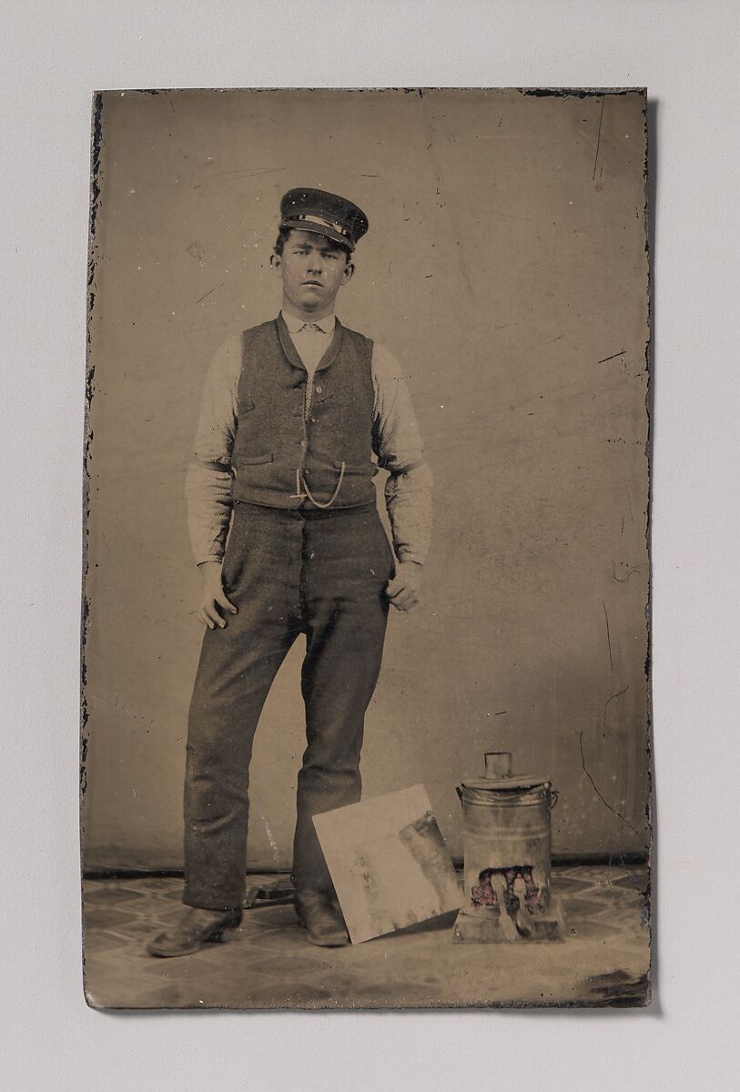 Unknown | [Tinsmith with Coal Heater and Sheet of Tin] | The