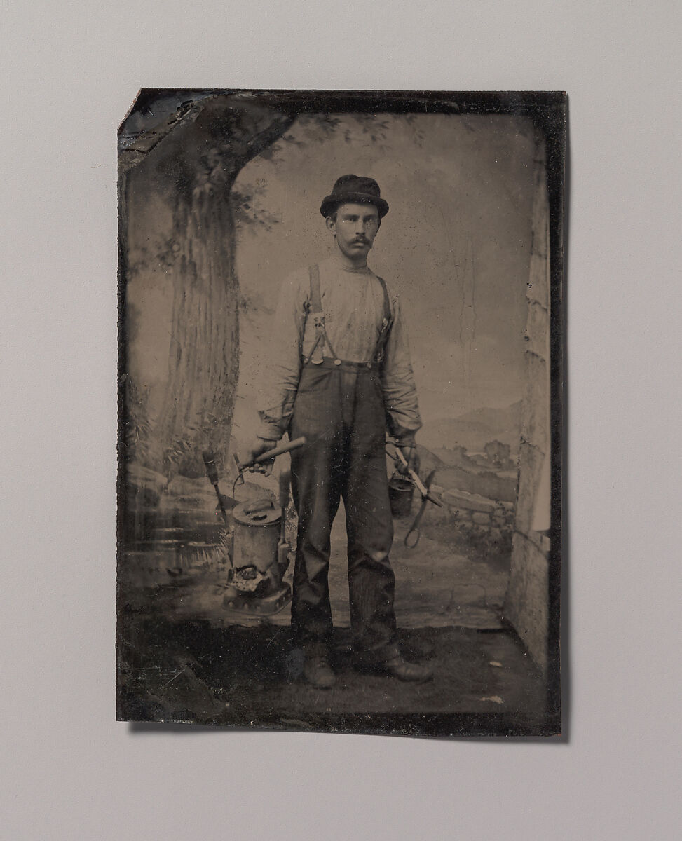 Unknown | [Tinsmith in Front of Painted Outdoor Backdrop] | The