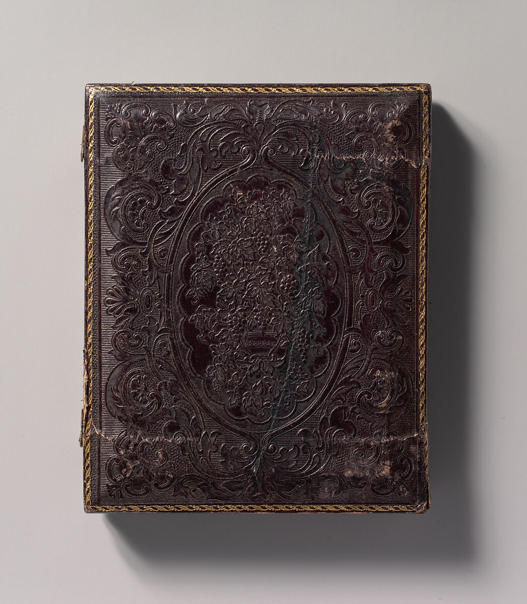 [Two Men, One in Military Garb, and a Woman, Seated Around a Table], Unknown (American), Ambrotype with applied color