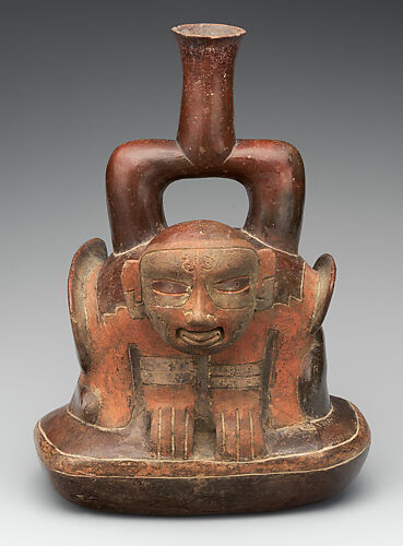 Stirrup-spout vessel with figure in a shell
