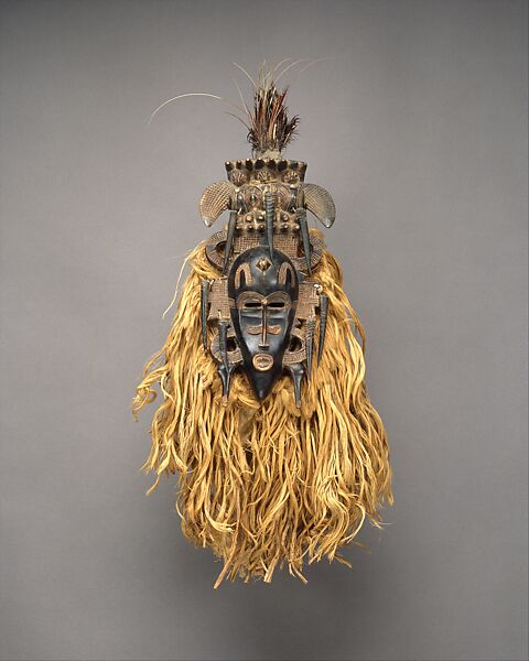 Face Mask (Kpeliye'e), Wood, horns, raffia fiber, cotton cloth, feather, metal, sacrificial material, Senufo peoples 