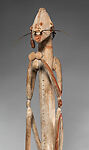 Male ancestor figure, Asmat artist, Wood, paint, sago palm leaves, fibers, mulberry fiber, pig tusk, cassowary quills, hair, coix seed, Asmat people