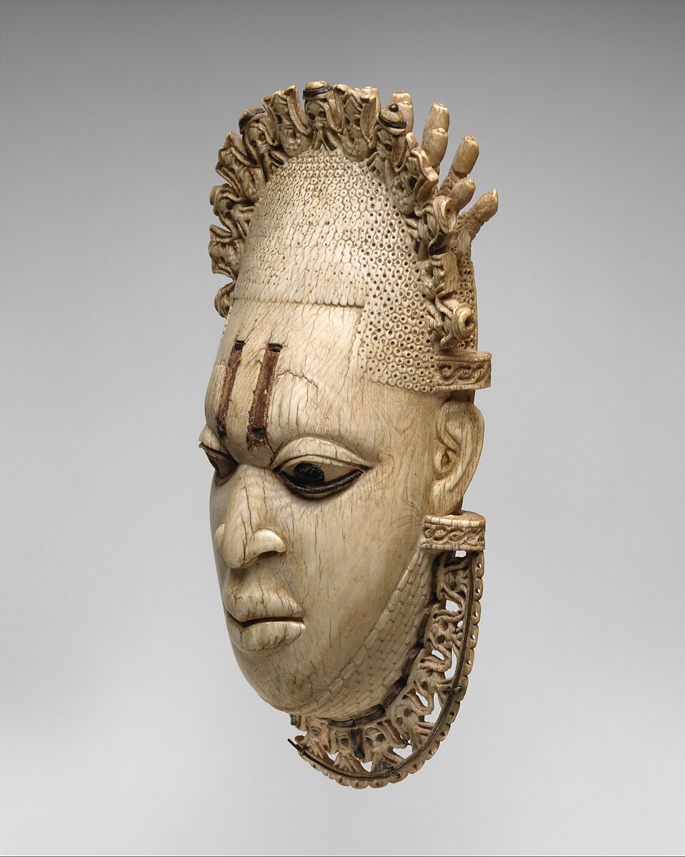 Pendant mask of Ìyọ́bà Idià, Ìgbèsànmwà (ivory- and wood- carving guild) artists, Ivory, iron, brass, coal, traces of iron oxides, Edo peoples