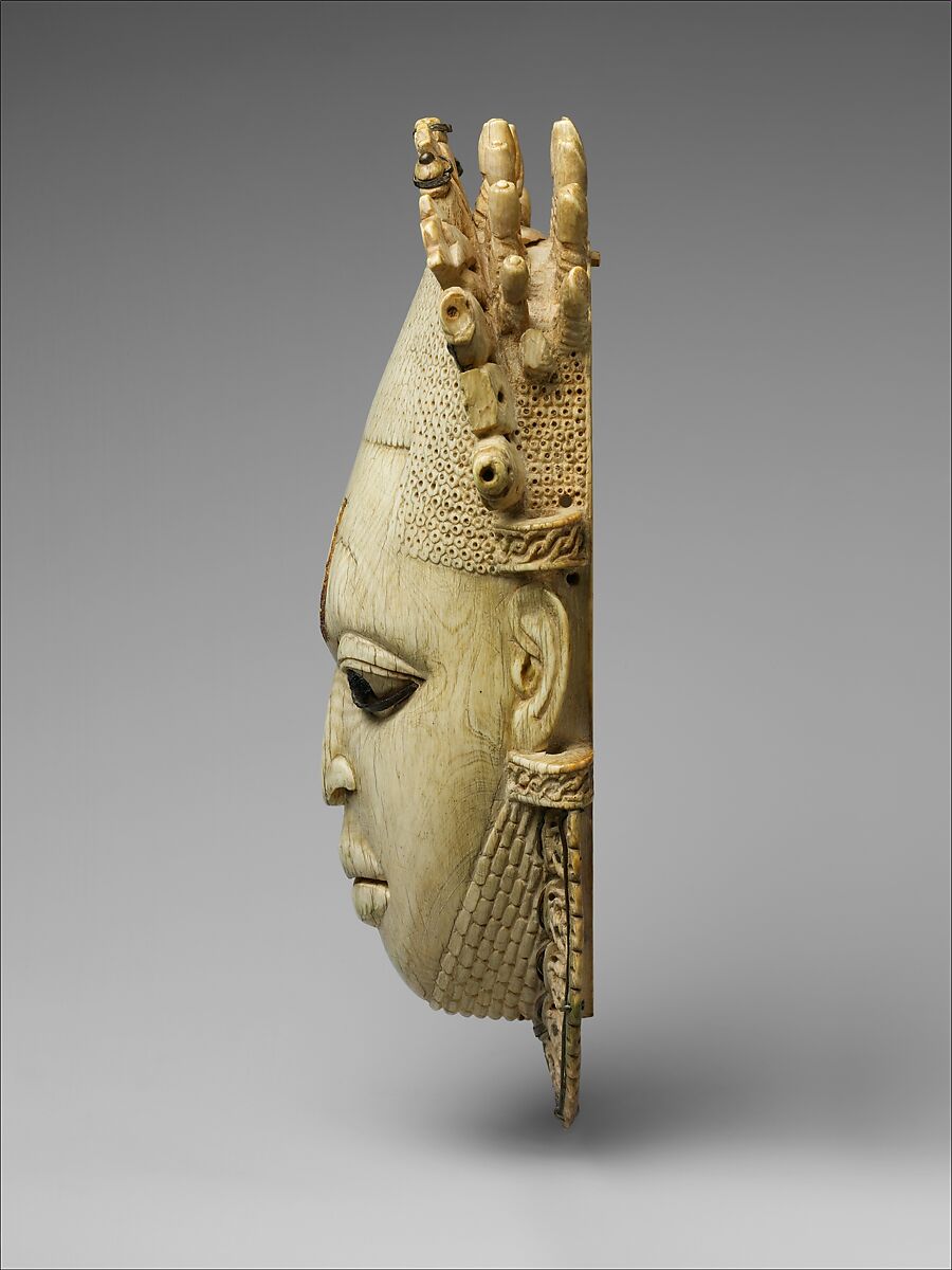 Pendant mask of Ìyọ́bà Idià, Ìgbèsànmwà (ivory- and wood- carving guild) artists, Ivory, iron, brass, coal, traces of iron oxides, Edo peoples