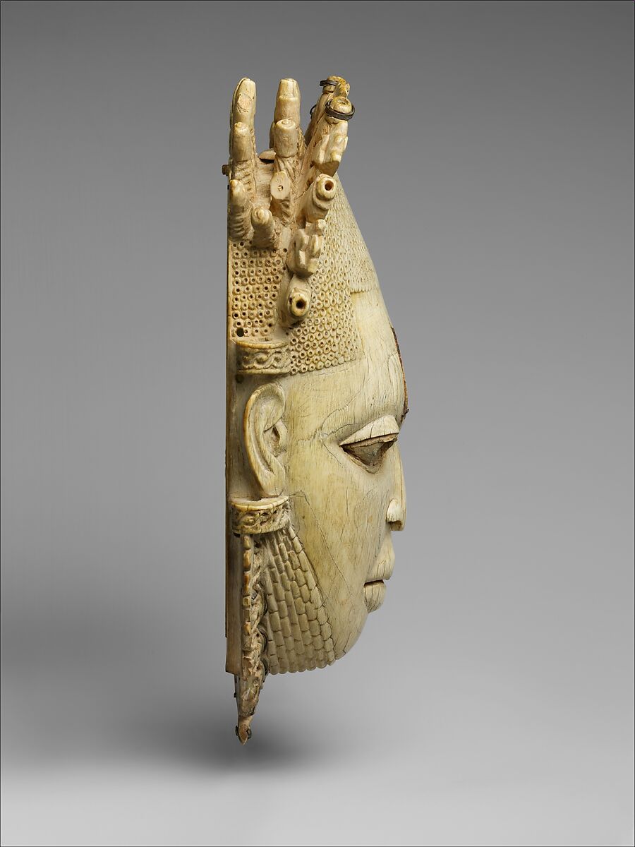 Pendant mask of Ìyọ́bà Idià, Ìgbèsànmwà (ivory- and wood- carving guild) artists, Ivory, iron, brass, coal, traces of iron oxides, Edo peoples