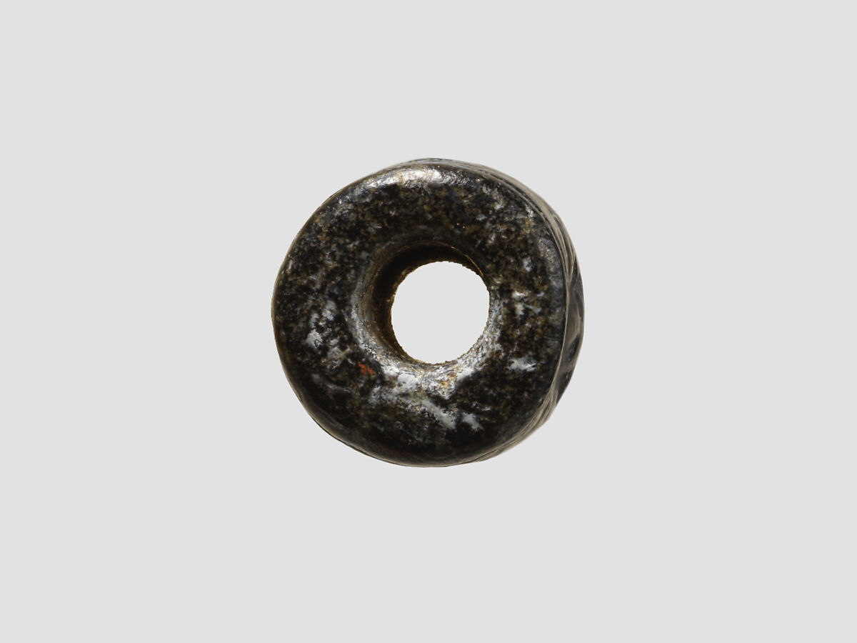 Cylinder seal and modern impression: man grasping an antelope, bull's head over ingot, Black-grey steatite, Cypriot