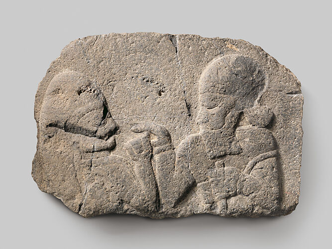 Relief: man holding up a cup to a woman