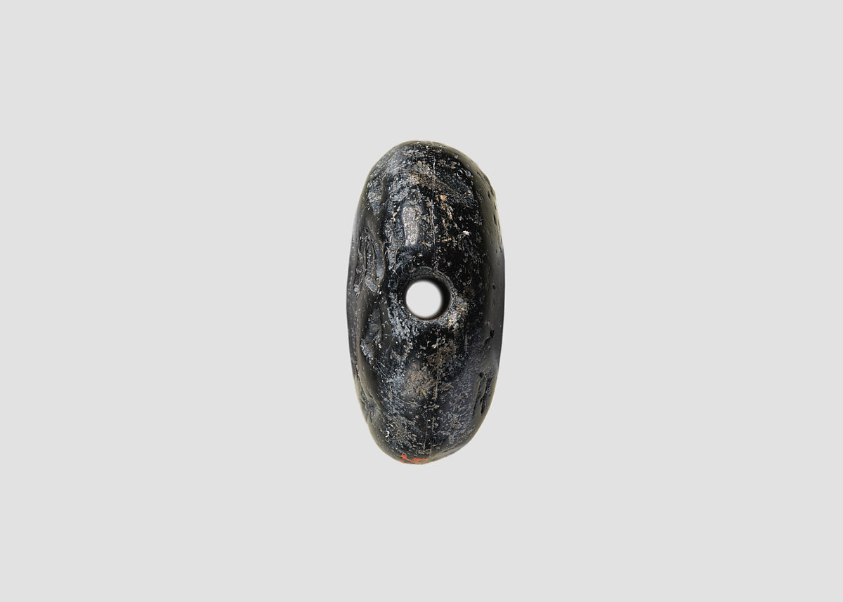 Double convex discoid (bulla) seal engraved on two faces, Black steatite, Hittite