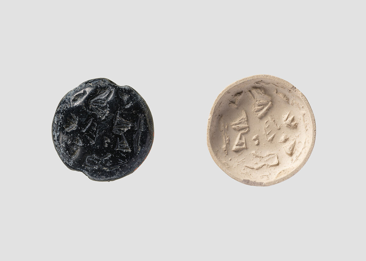 Double convex discoid (bulla) seal engraved on two faces, Black steatite, Hittite 