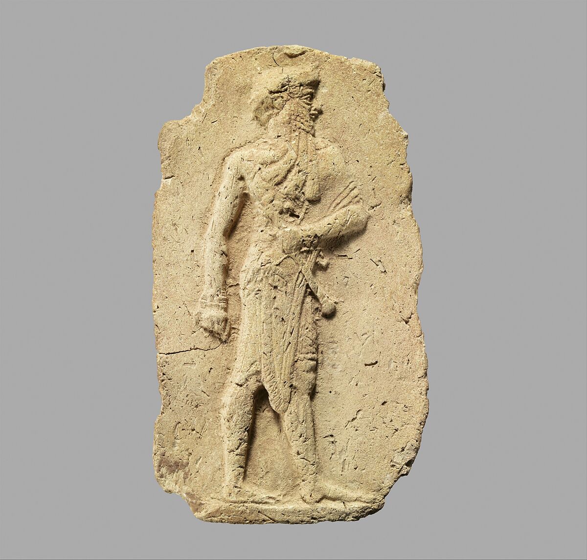 Molded plaque: king or a god carrying a mace