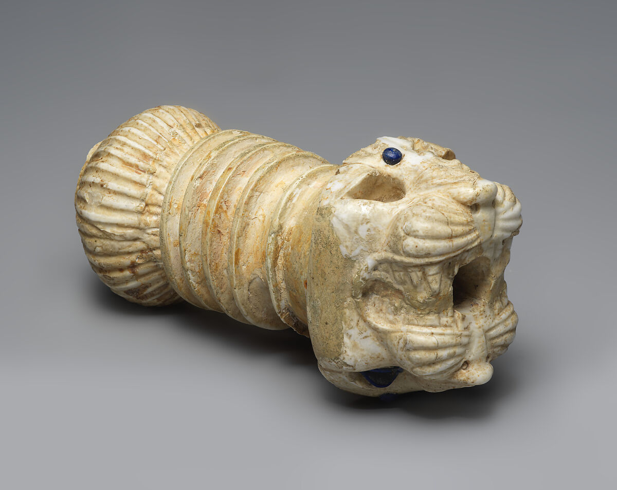Ornament with heads of roaring lions, possibly the terminal of a sword or dagger hilt, Limestone, lapis lazuli, faience inlay, Assyrian