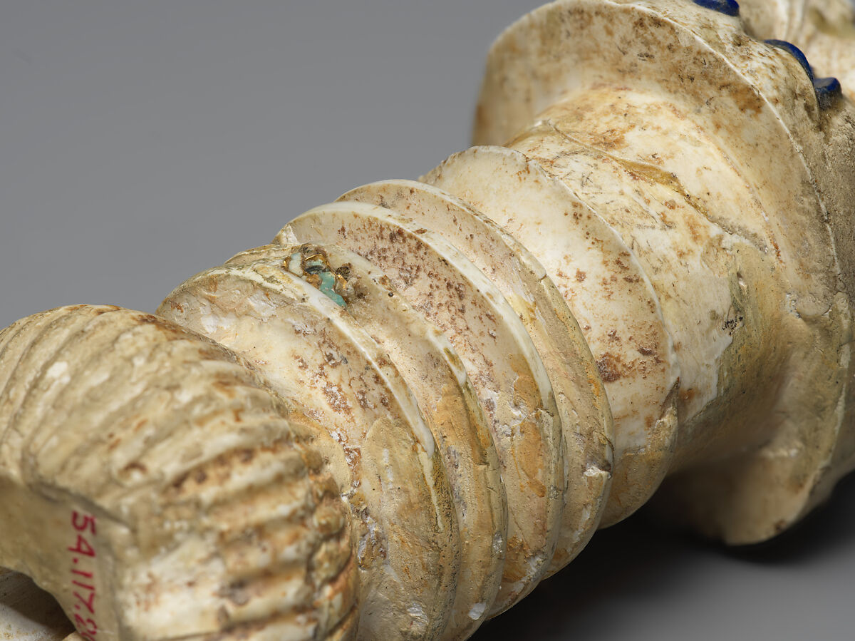 Ornament with heads of roaring lions, possibly the terminal of a sword or dagger hilt, Limestone, lapis lazuli, faience inlay, Assyrian