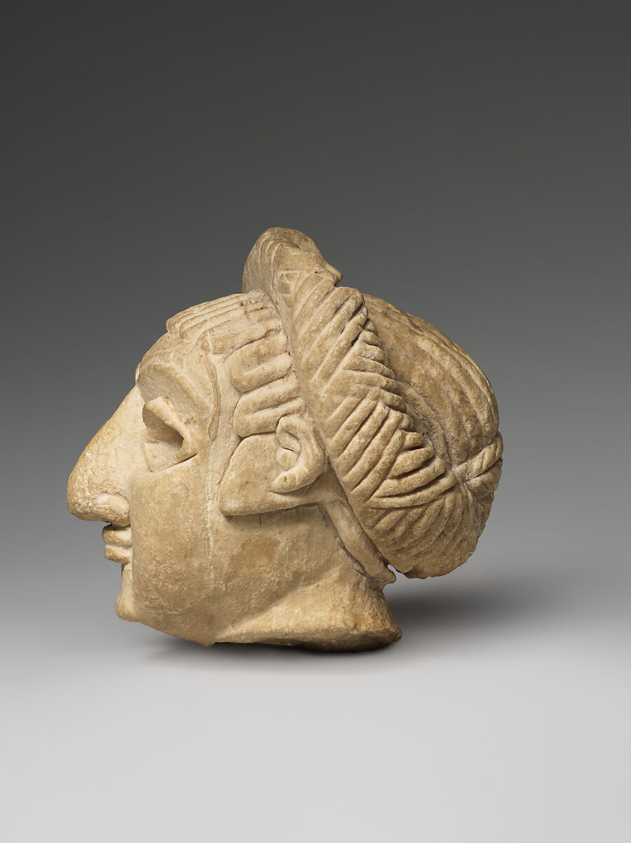 Female head with elaborate hairstyle, Limestone