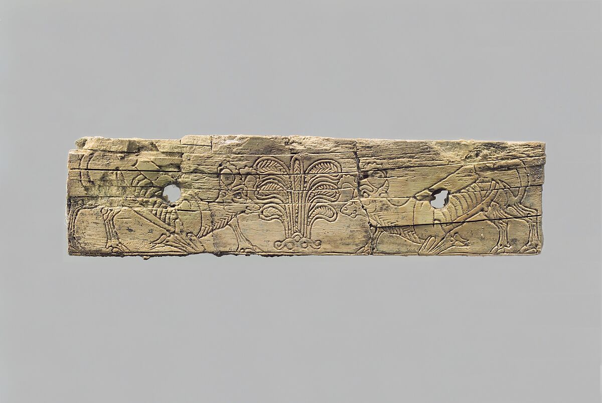 Incised furniture plaque with two ibexes flanking a stylized palmette tree, Ivory, Assyrian 