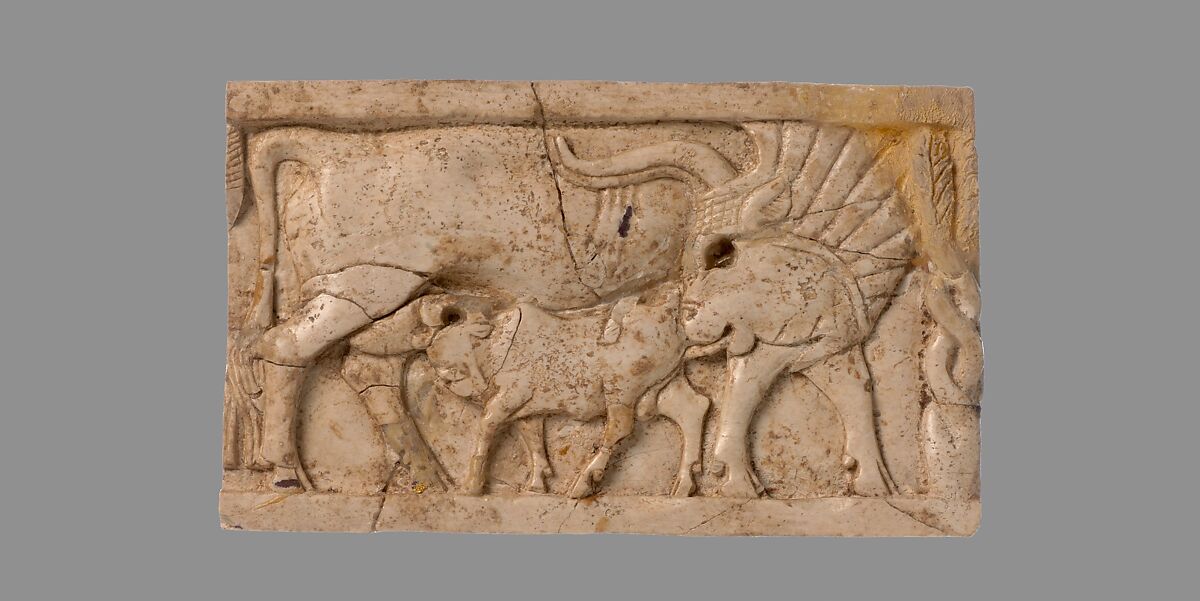 Furniture plaque carved in relief with a cow suckling a calf, Ivory, Assyrian 