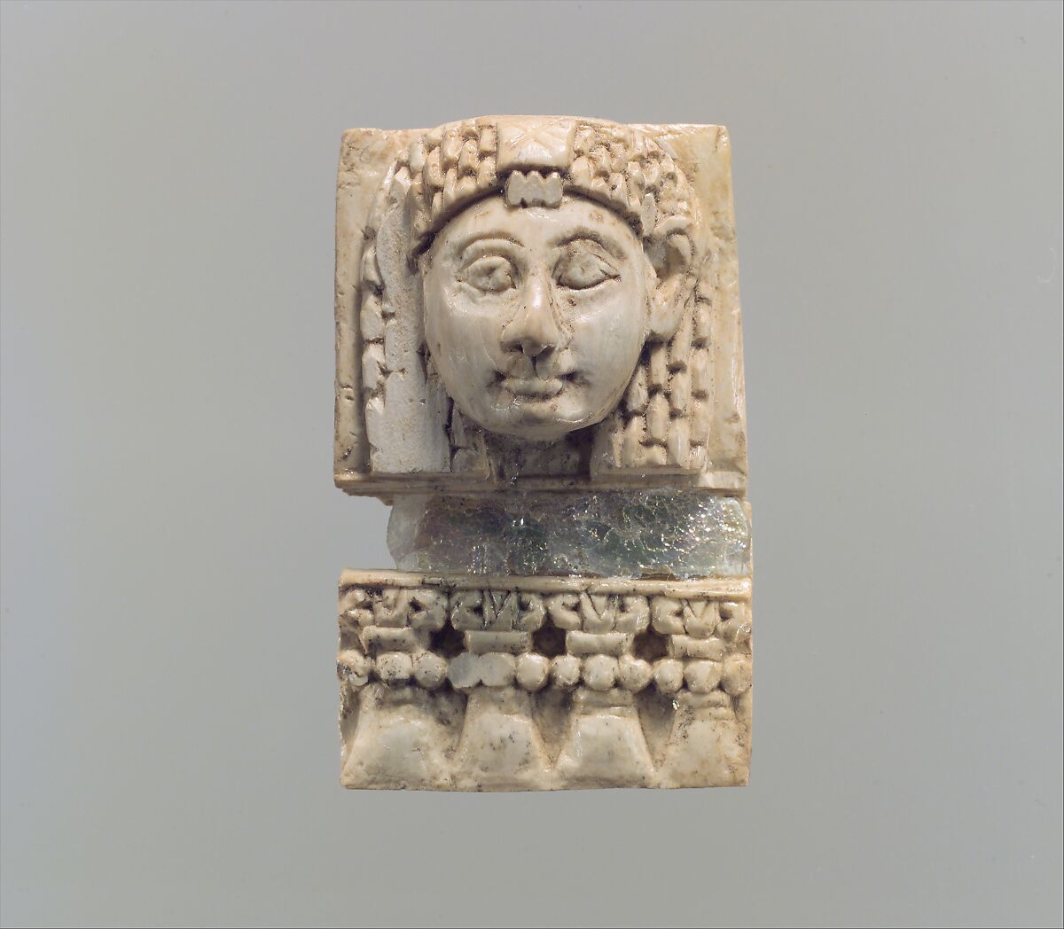 Furniture plaque carved in relief with a “woman at the window”, Ivory, glass, Assyrian 