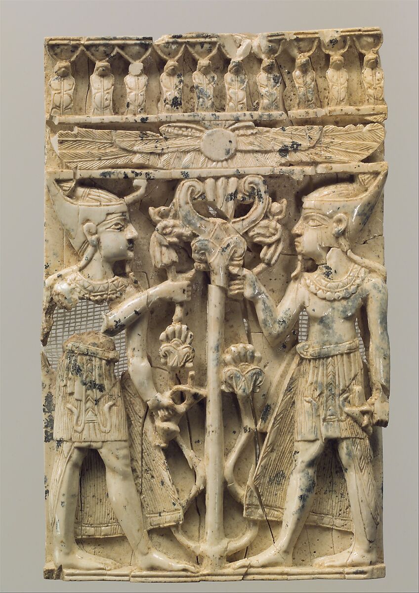 Furniture plaque carved in high relief with two Egyptianizing figures flanking a volute tree