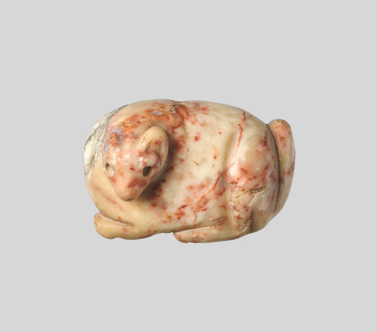 Seal amulet in the form of a recumbent fox, Marble, cream with red veins (?) 