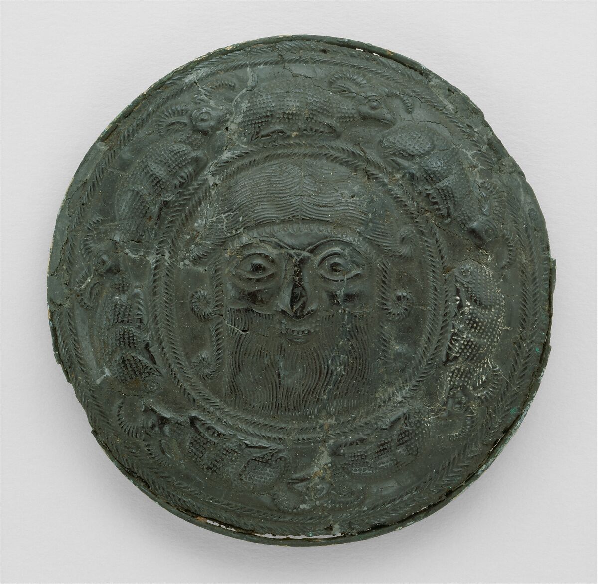 Roundel with head of a "hero" surrounded by caprids, Bitumen, gold and silver foil, Elamite