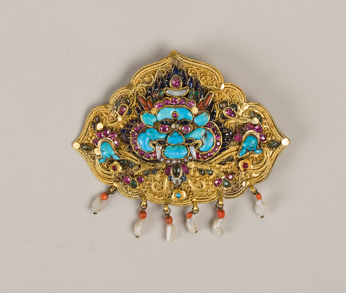 Woman’s Brooch with Monster Mask, Gilt silver, rubies, sapphires, emeralds, coral, pearls, mother-of-pearl, and turquoise, Nepal 