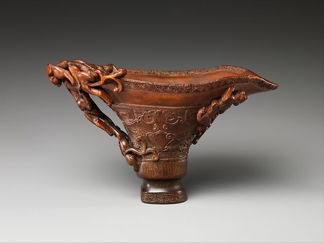 Cup in the shape of an archaic vessel with feline dragons