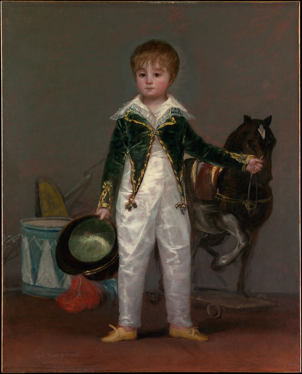 Portrait of a young boy wearing his dad's work clothes and holding