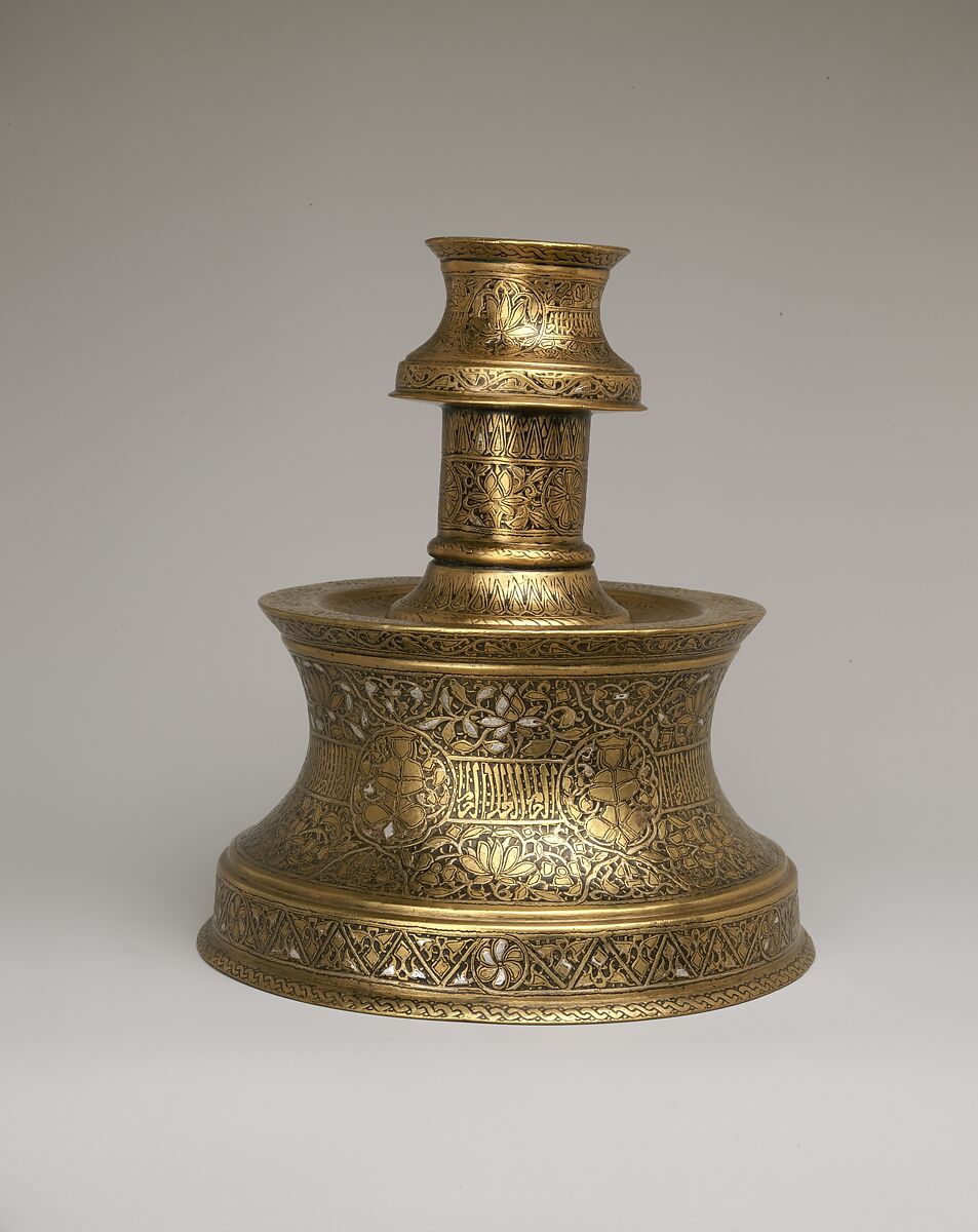 Candlestick with Repeating Seated Figure, Inscription, and Flowers, Brass; cast, engraved, and originally inlaid with silver 
