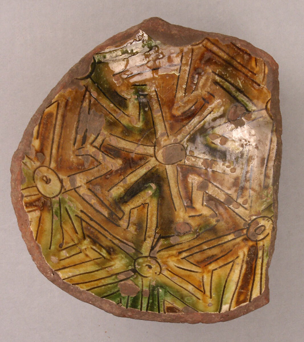 Fragment of a Bowl, reddish earthenware; white slip; green and rust underglaze; transparent glaze 