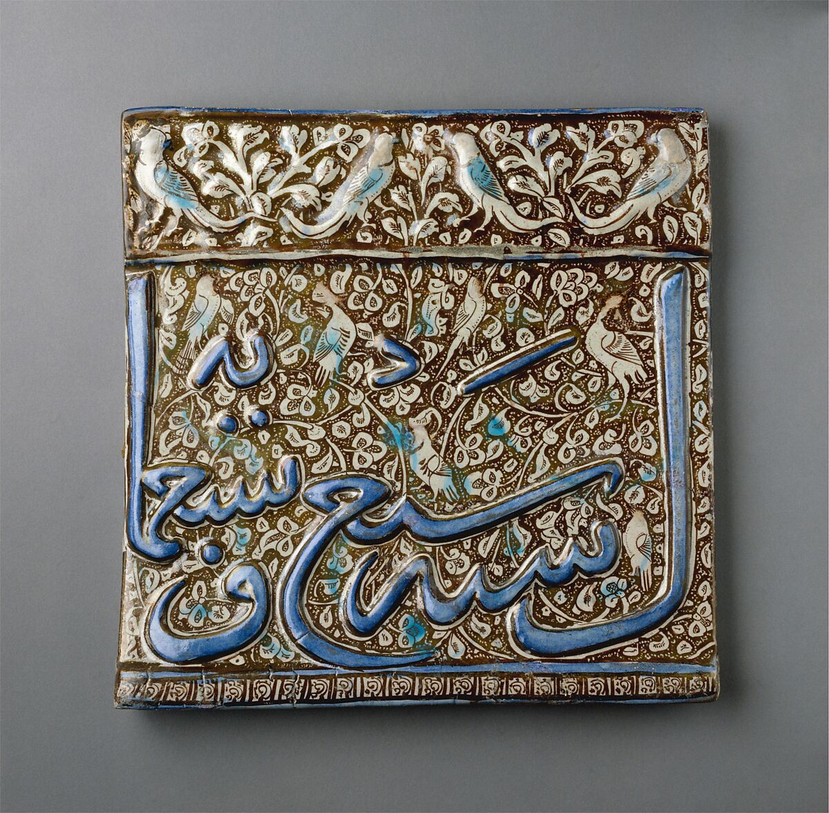 Tile From an Inscriptional Frieze, Stonepaste; underglaze painted in blue, luster-painted on opaque white ground, modeled