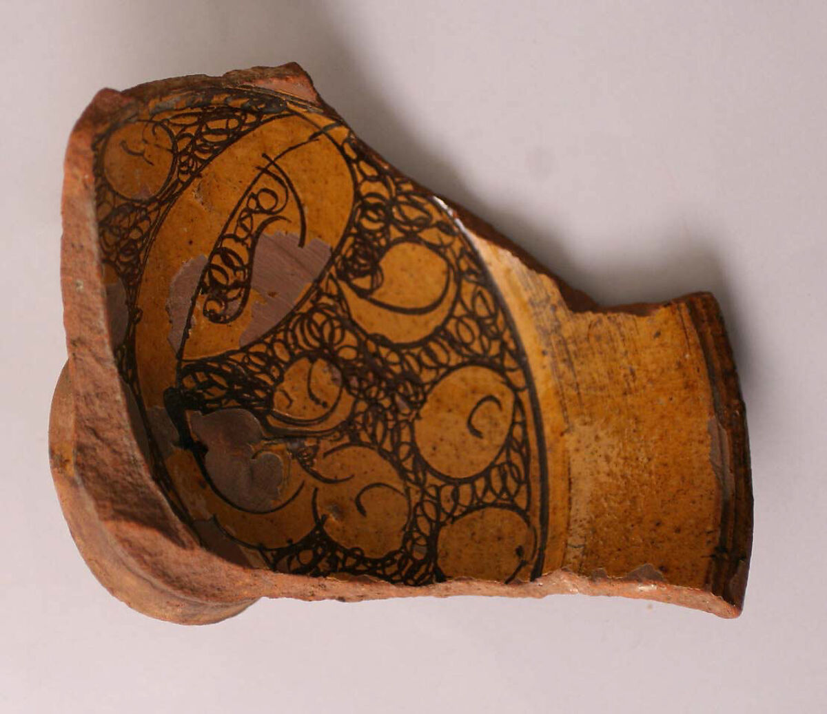 Fragment of a Bowl, Earthenware; incised decoration through white slip and coloring under transparent glaze. 