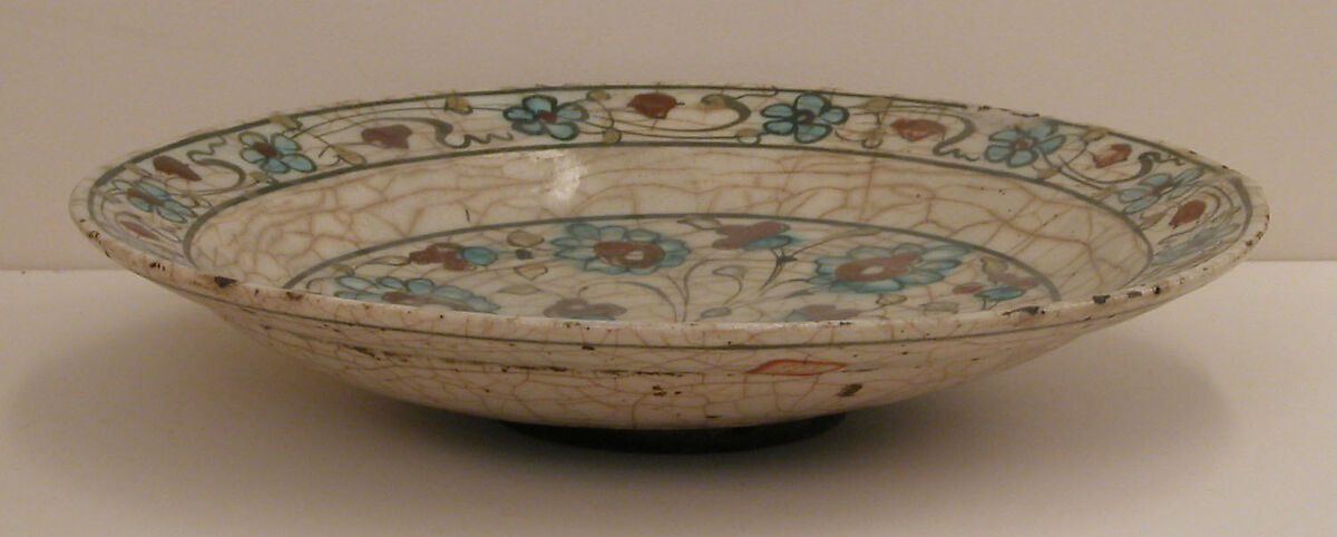 Dish, Stonepaste; underglaze painted in black and green with red and yellow slips